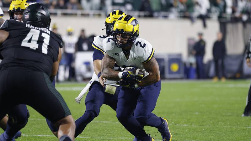 Michigan running back Blake Corum (2) takes a handoff during an NCAA college football game...