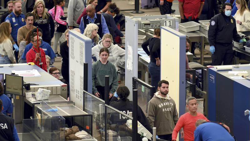 Travelers wait in a security line at Denver International Airport on Tuesday, Nov. 21, 2023, in...